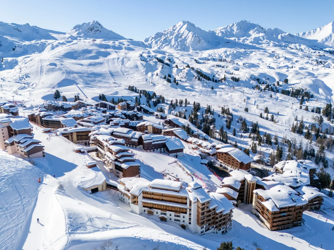 Station de ski enneigée avec montagnes en arrière-plan.