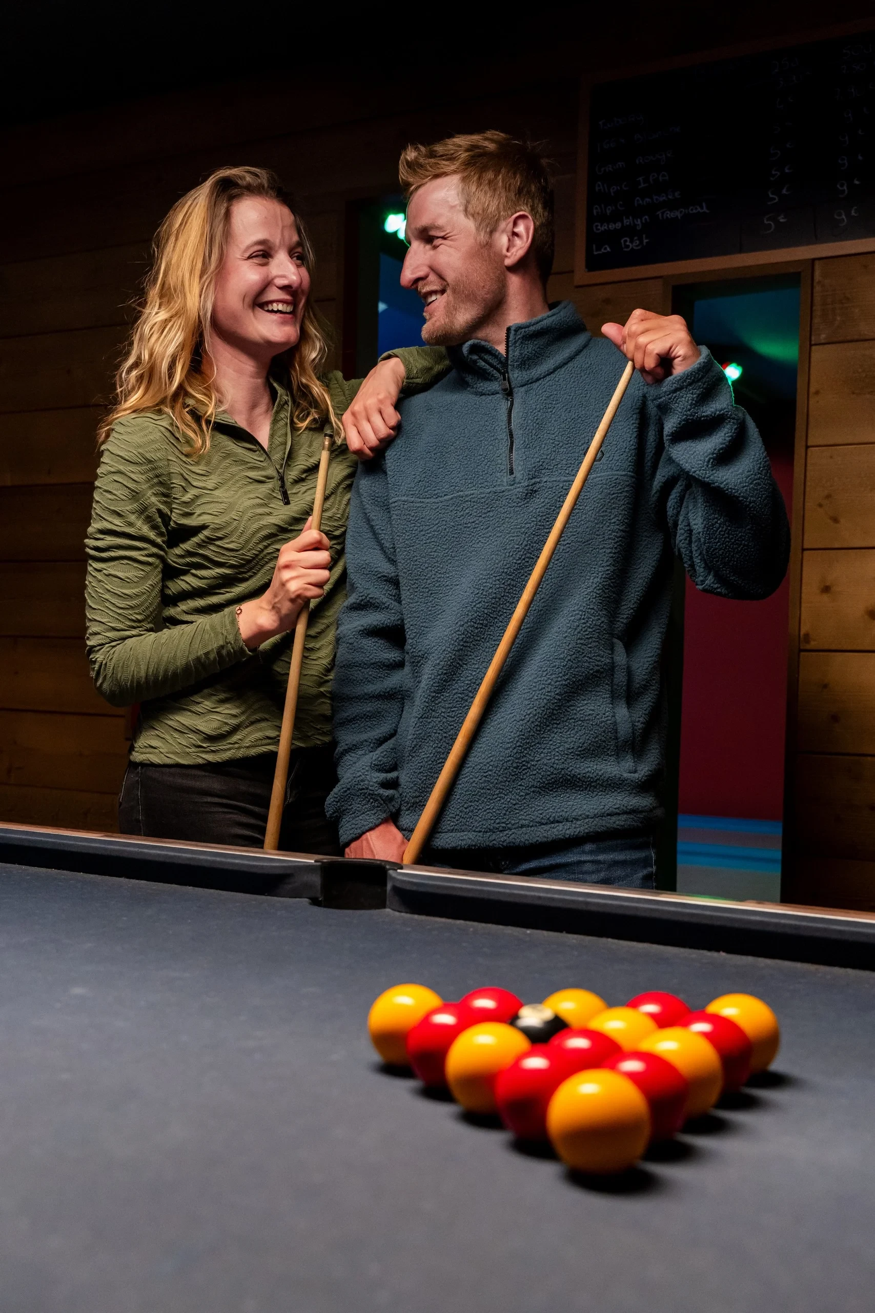 Deux personnes souriantes jouant au billard.