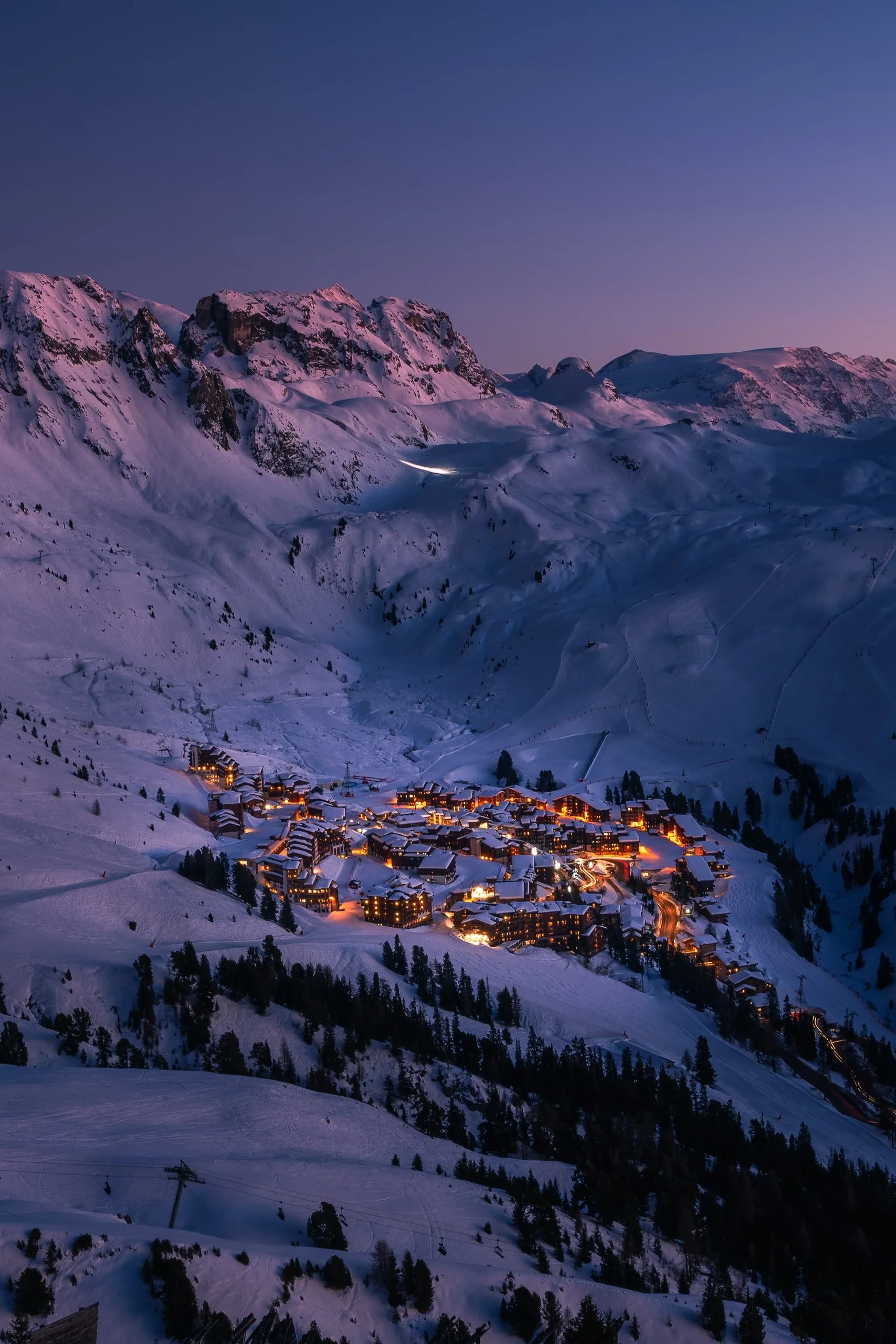 Village alpin enneigé illuminé au crépuscule