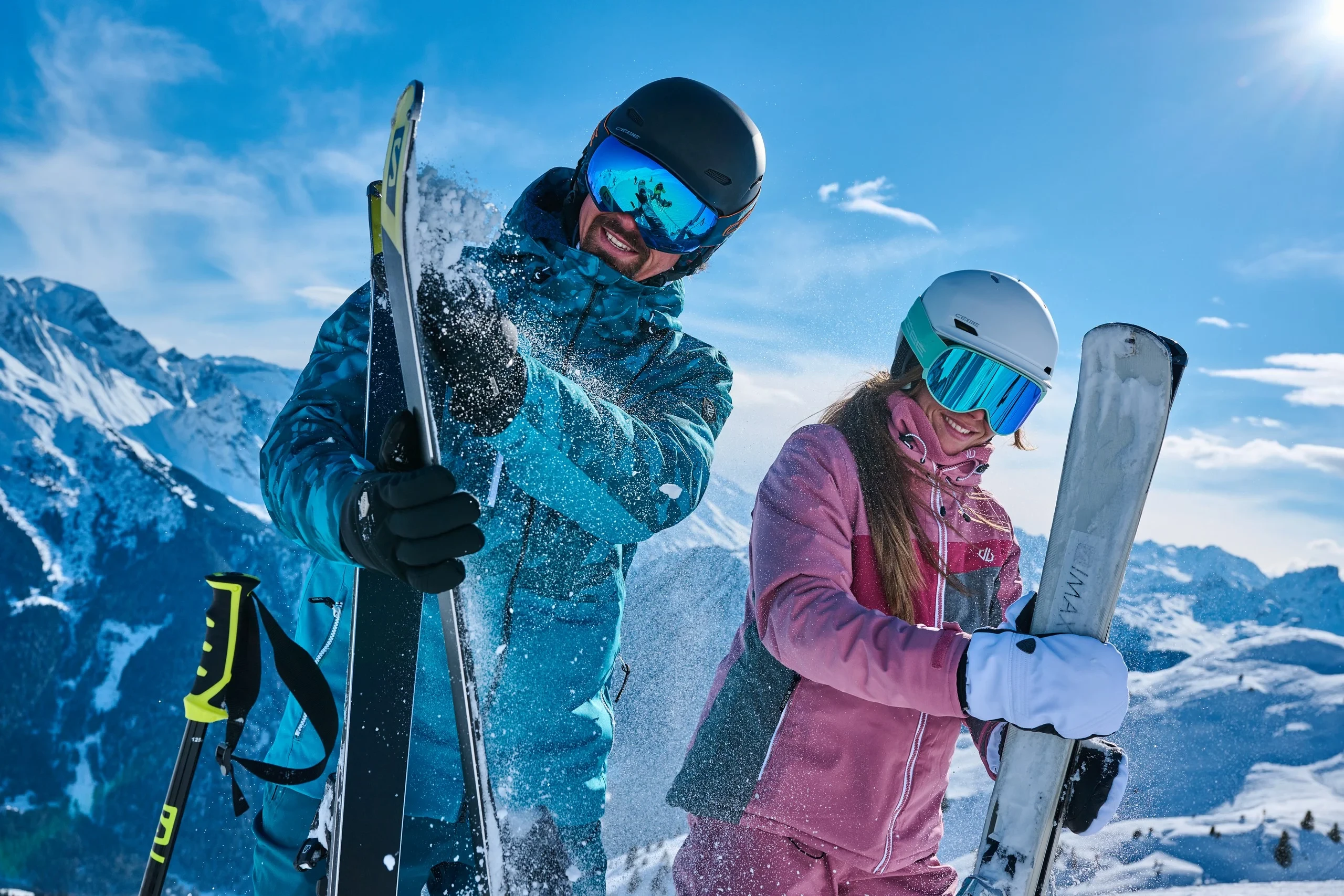 Deux skieurs souriants sur les pistes enneigées.