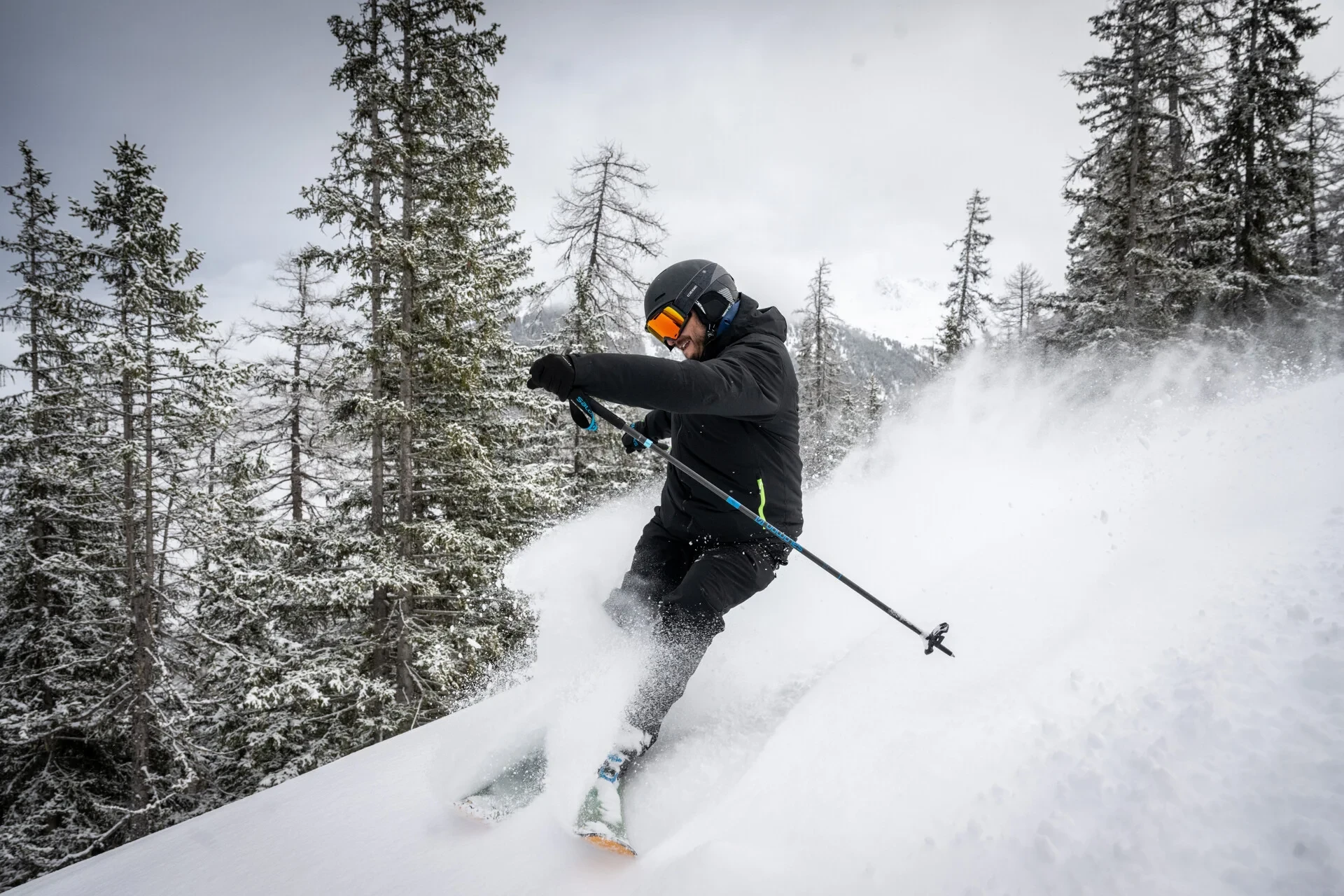 Skieur dévalant une pente enneigée en montagne.