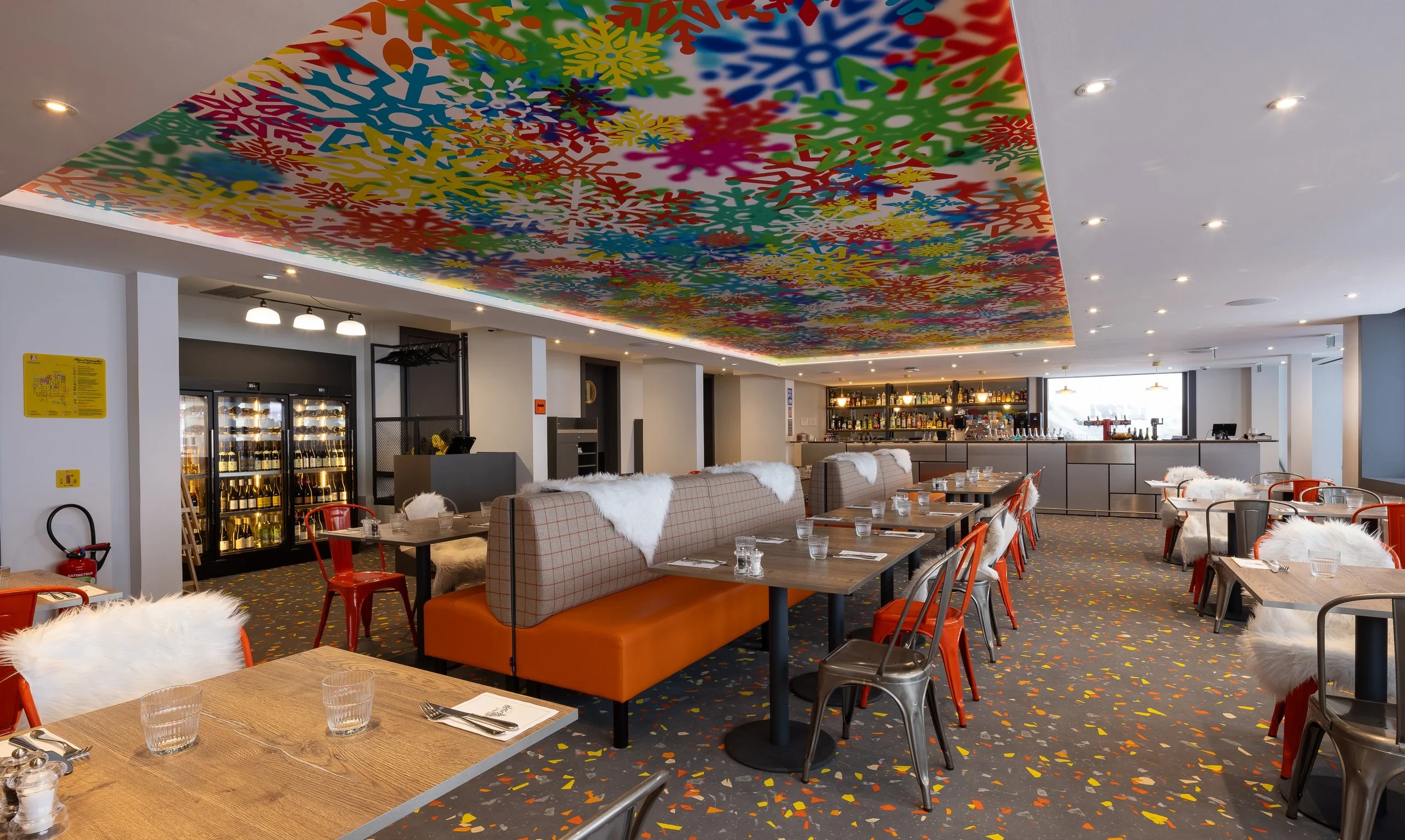 Restaurant moderne avec plafond coloré et sièges confortables.