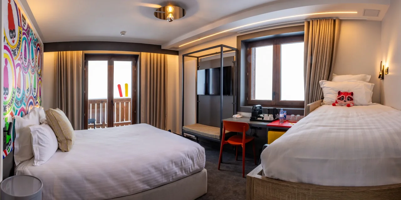 Chambre d'hôtel lumineuse avec deux lits.