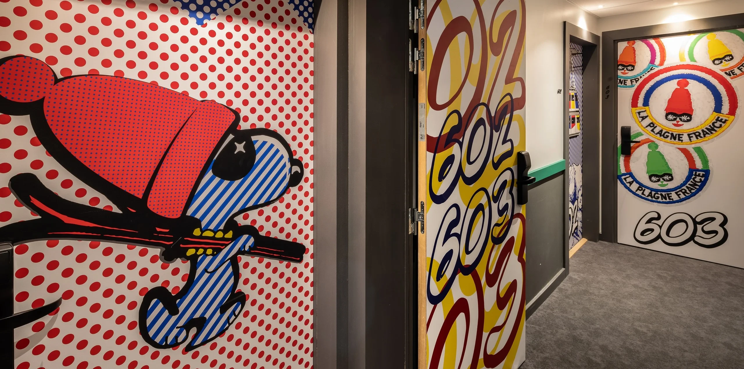 Décor mural coloré, dessins et numéros de chambre.