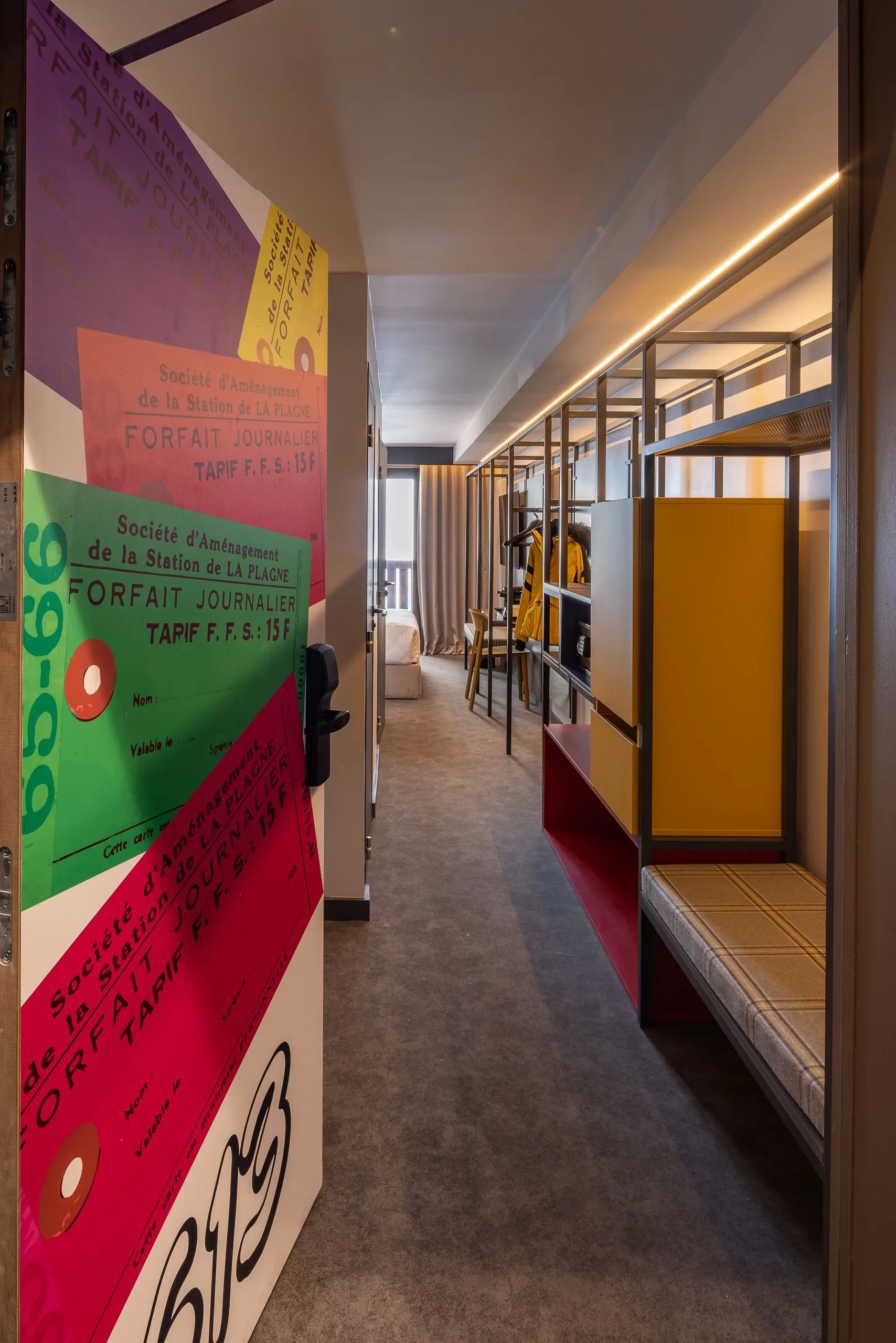 Intérieur de chambre moderne avec porte colorée ouverte.