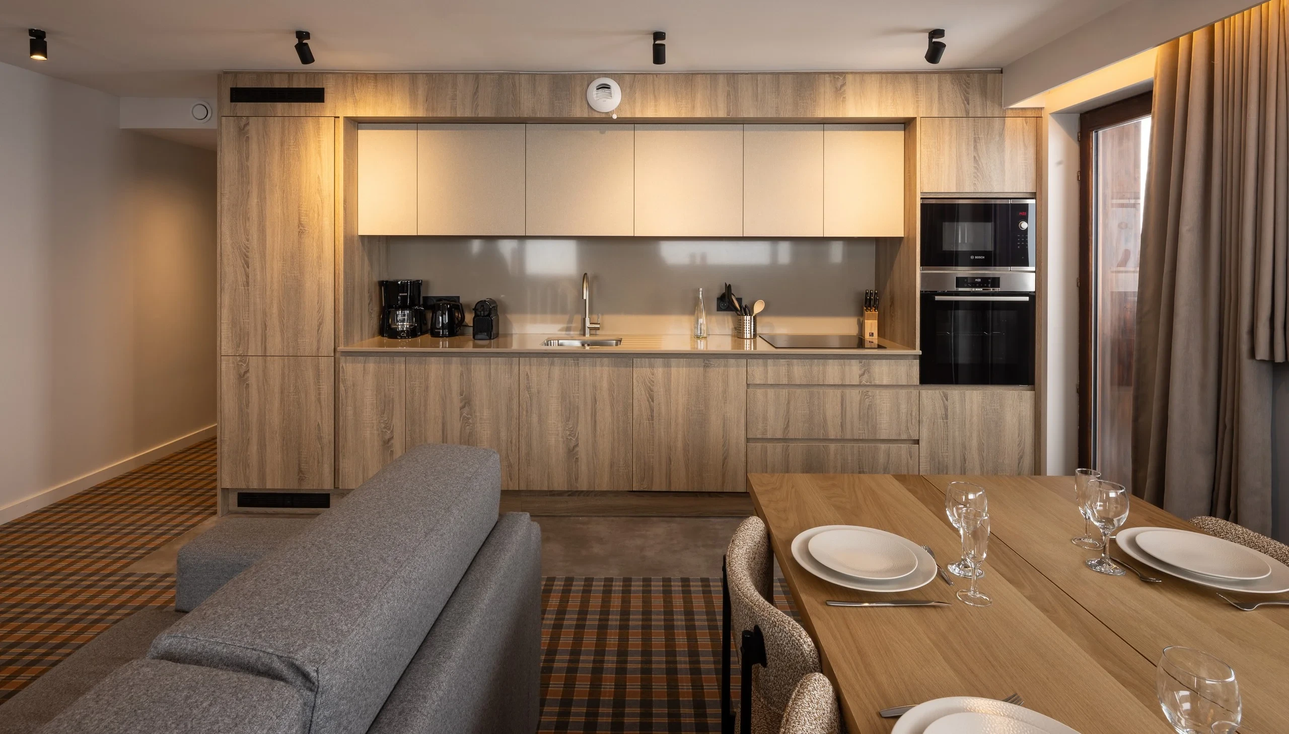 Cuisine moderne en bois clair avec table dressée.