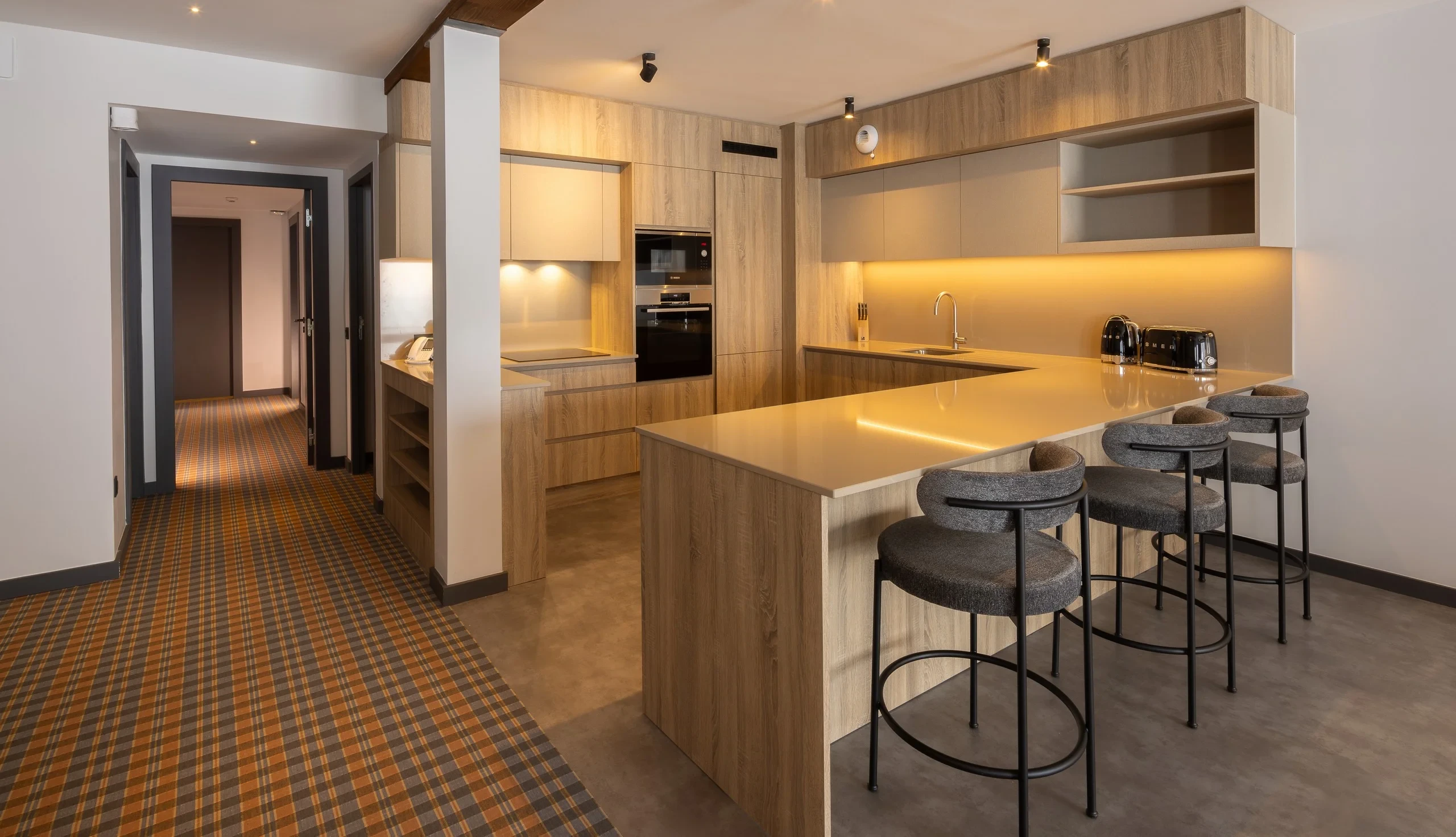 Cuisine moderne avec îlot central et tabourets.