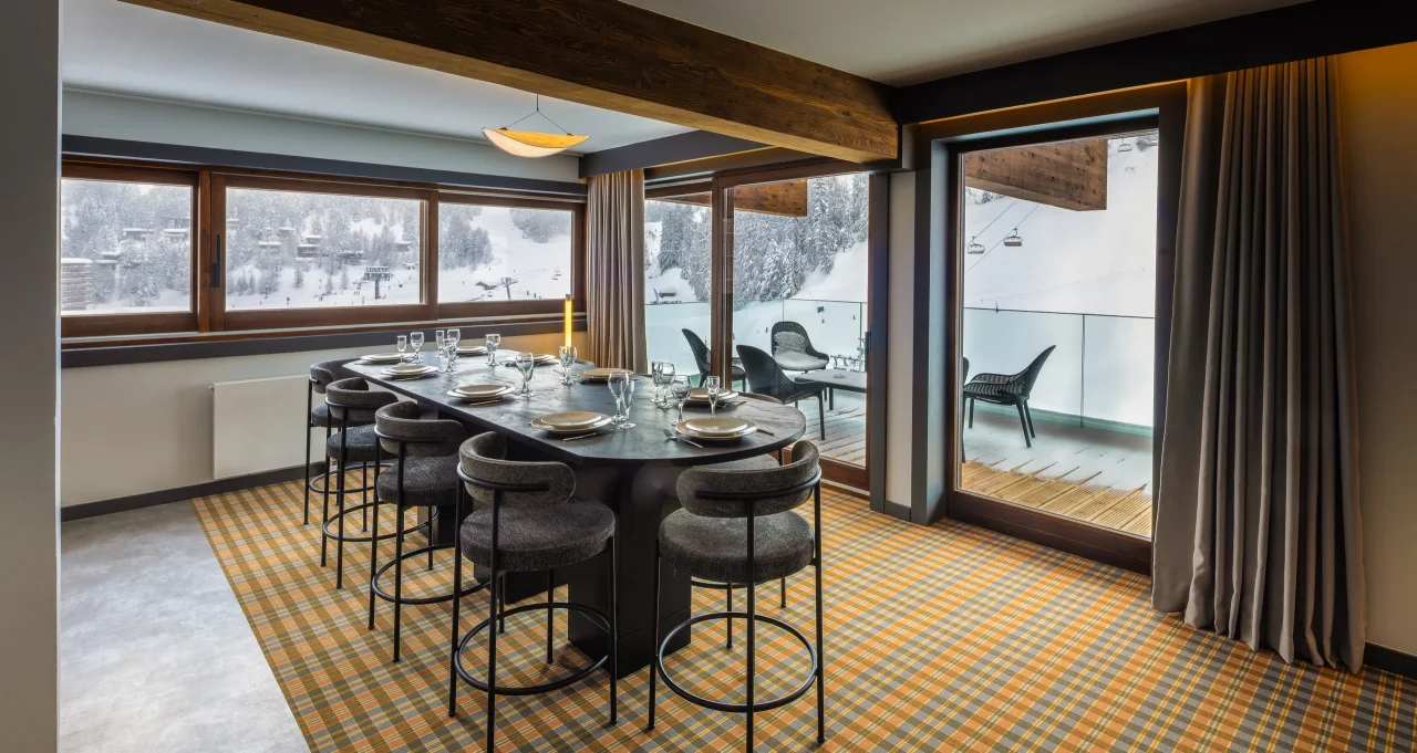 Salle à manger avec vue sur montagne enneigée.