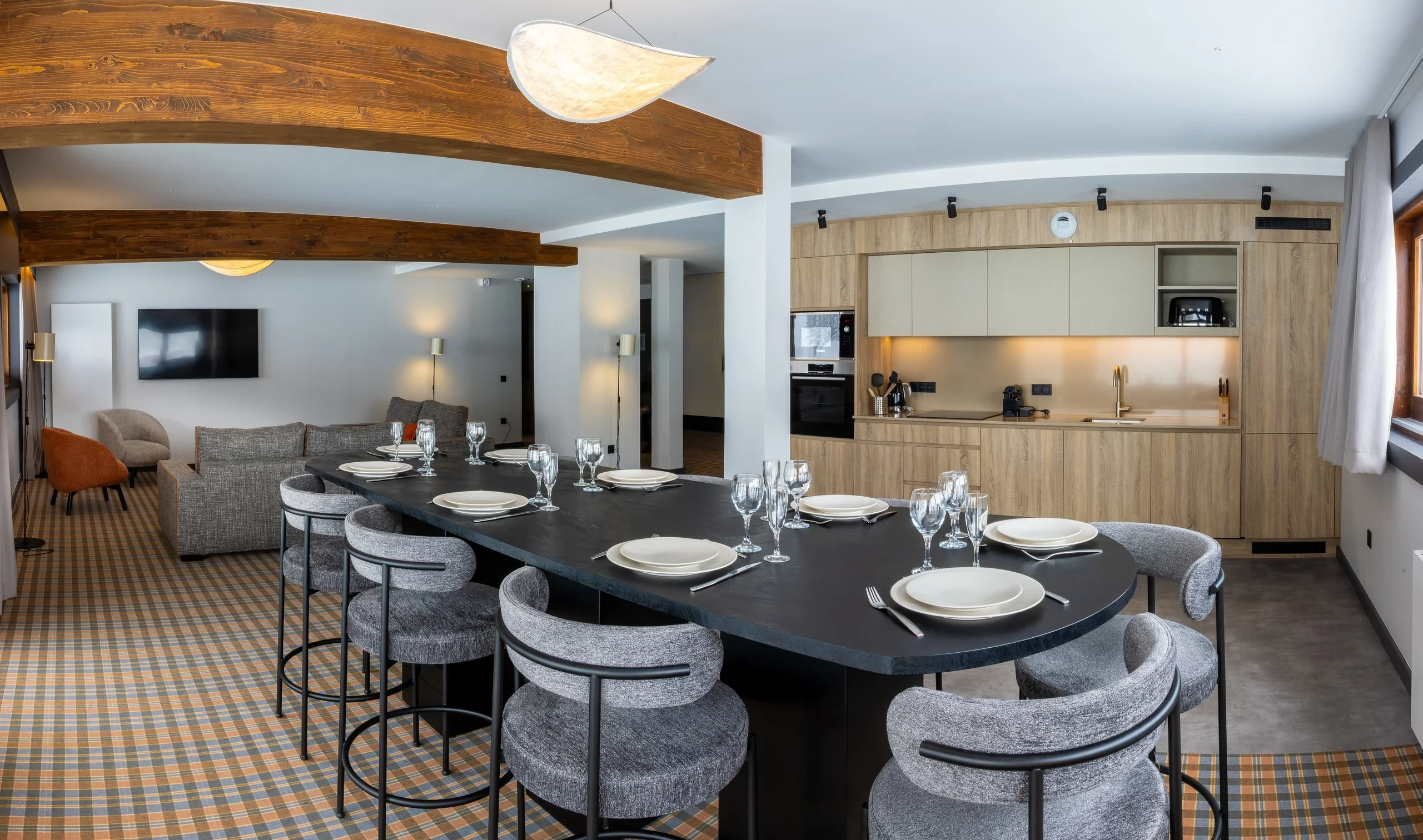 Cuisine moderne avec salon et table dressée.