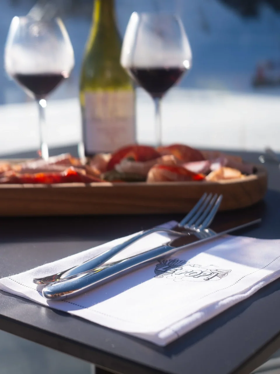 Table avec vin et charcuterie en terrasse.