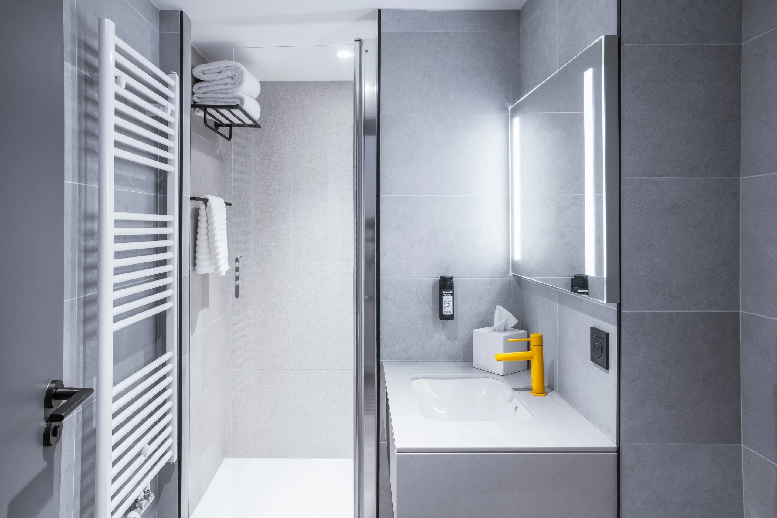 Salle de bain moderne avec miroir illuminé.