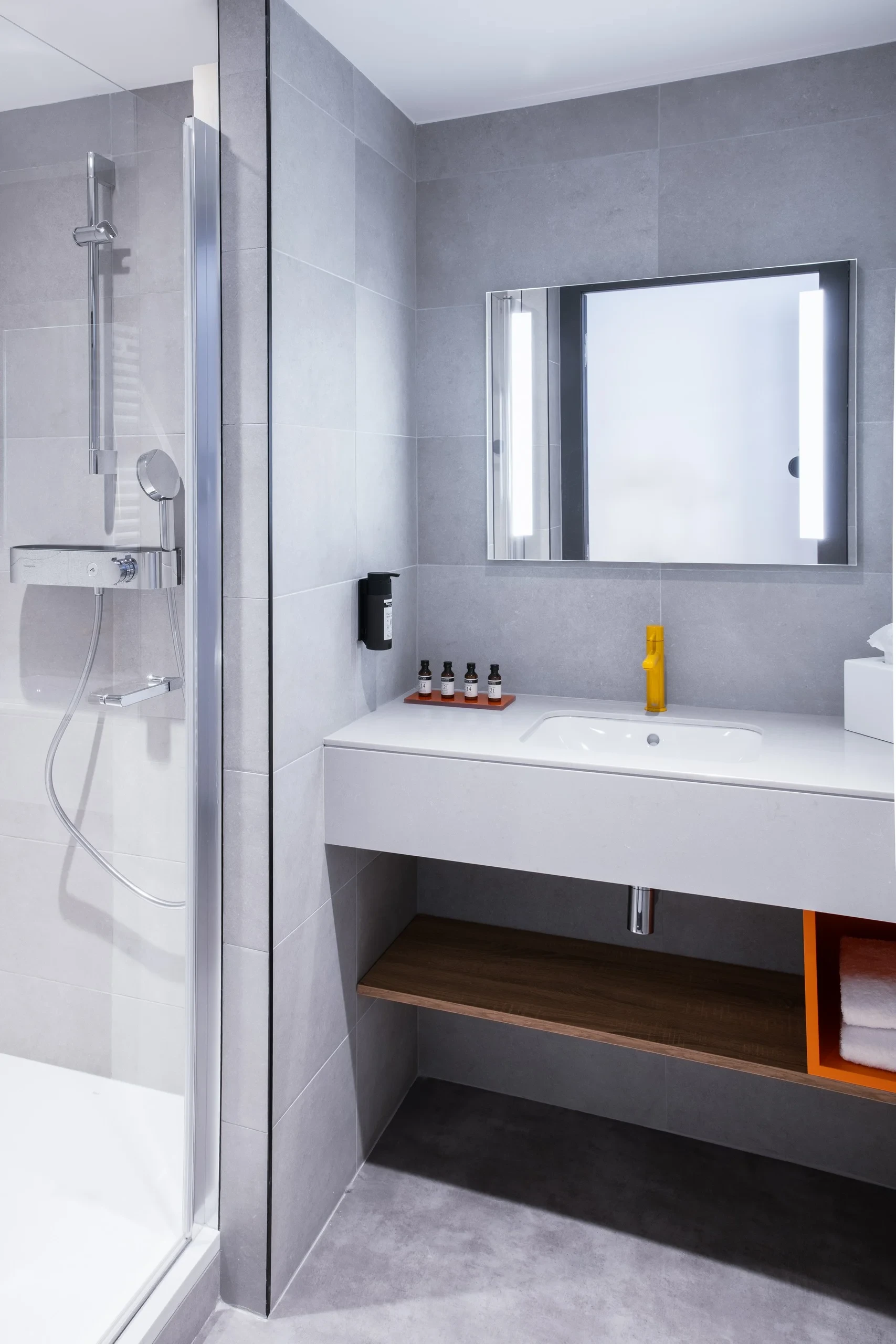Salle de bain moderne avec douche et lavabo.