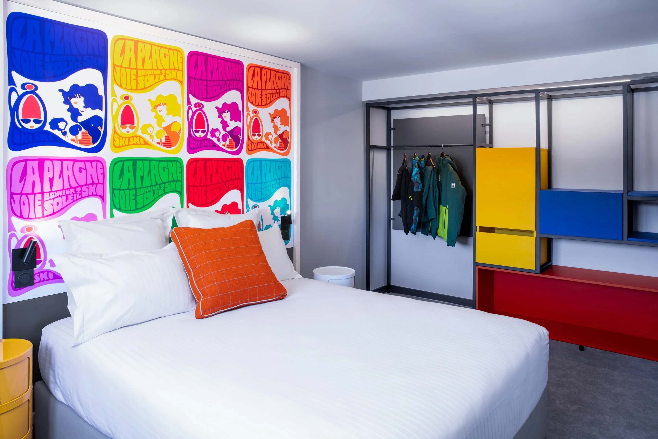 Chambre colorée avec posters et rangements vifs.