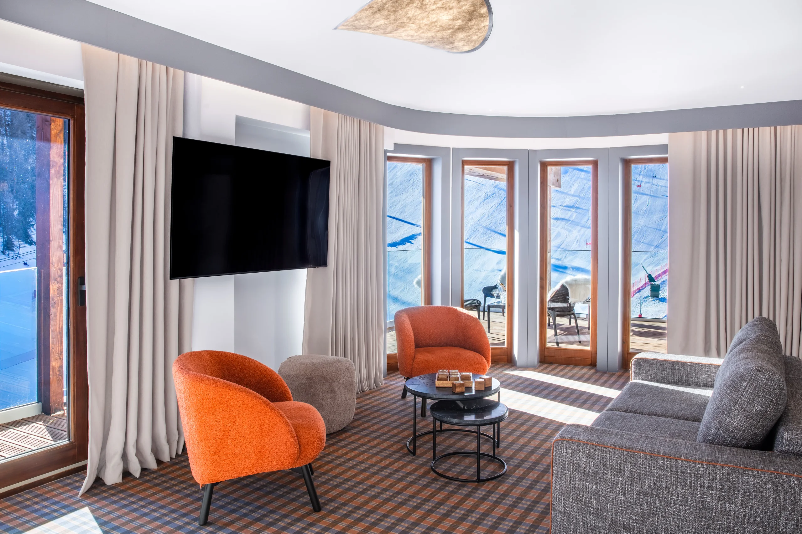 Salon moderne avec vue sur montagnes enneigées.
