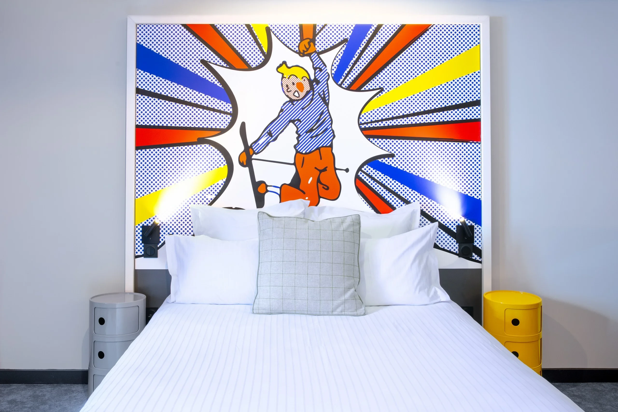 Chambre avec tête de lit art pop coloré.