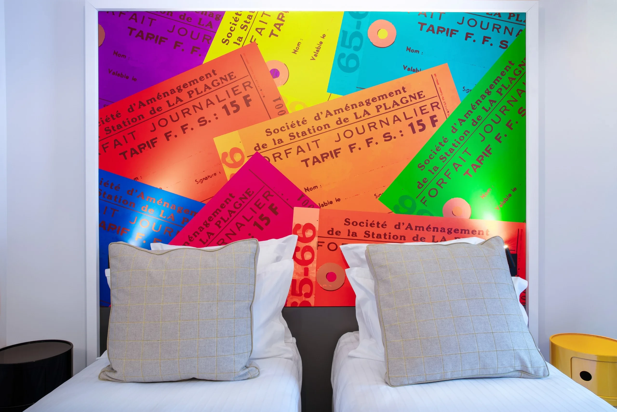 Chambre avec papier peint coloré et lits jumeaux.