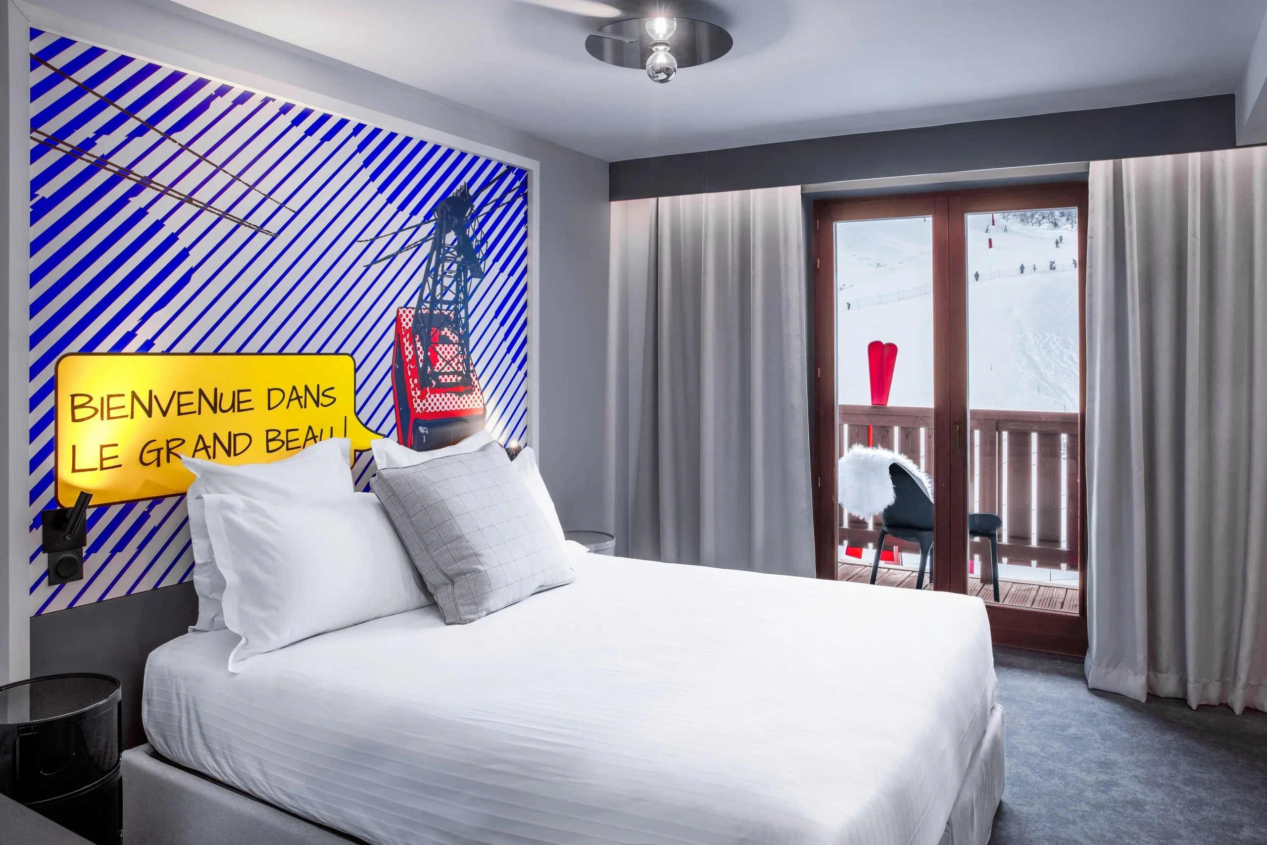 Chambre d'hôtel avec vue sur les pistes enneigées.