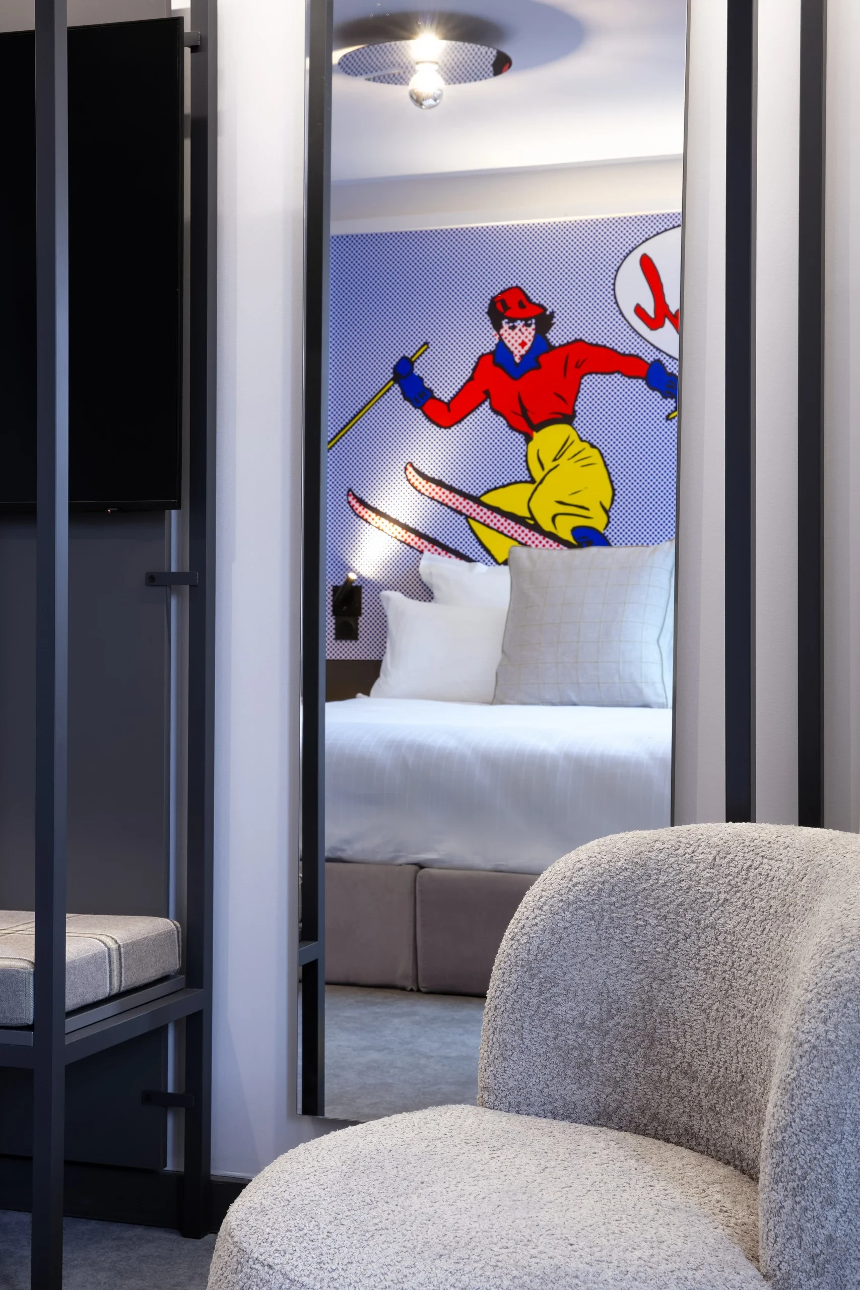 Chambre avec décoration murale de skieur coloré.