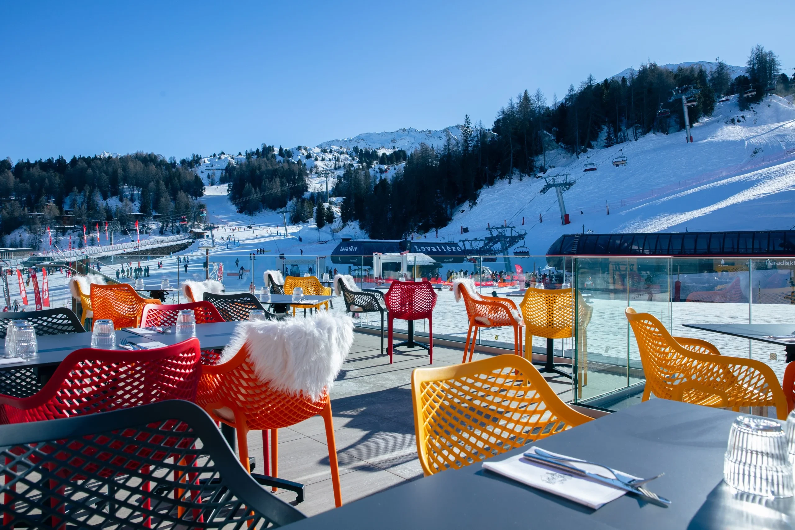 Terrasse avec vue sur piste de ski enneigée.