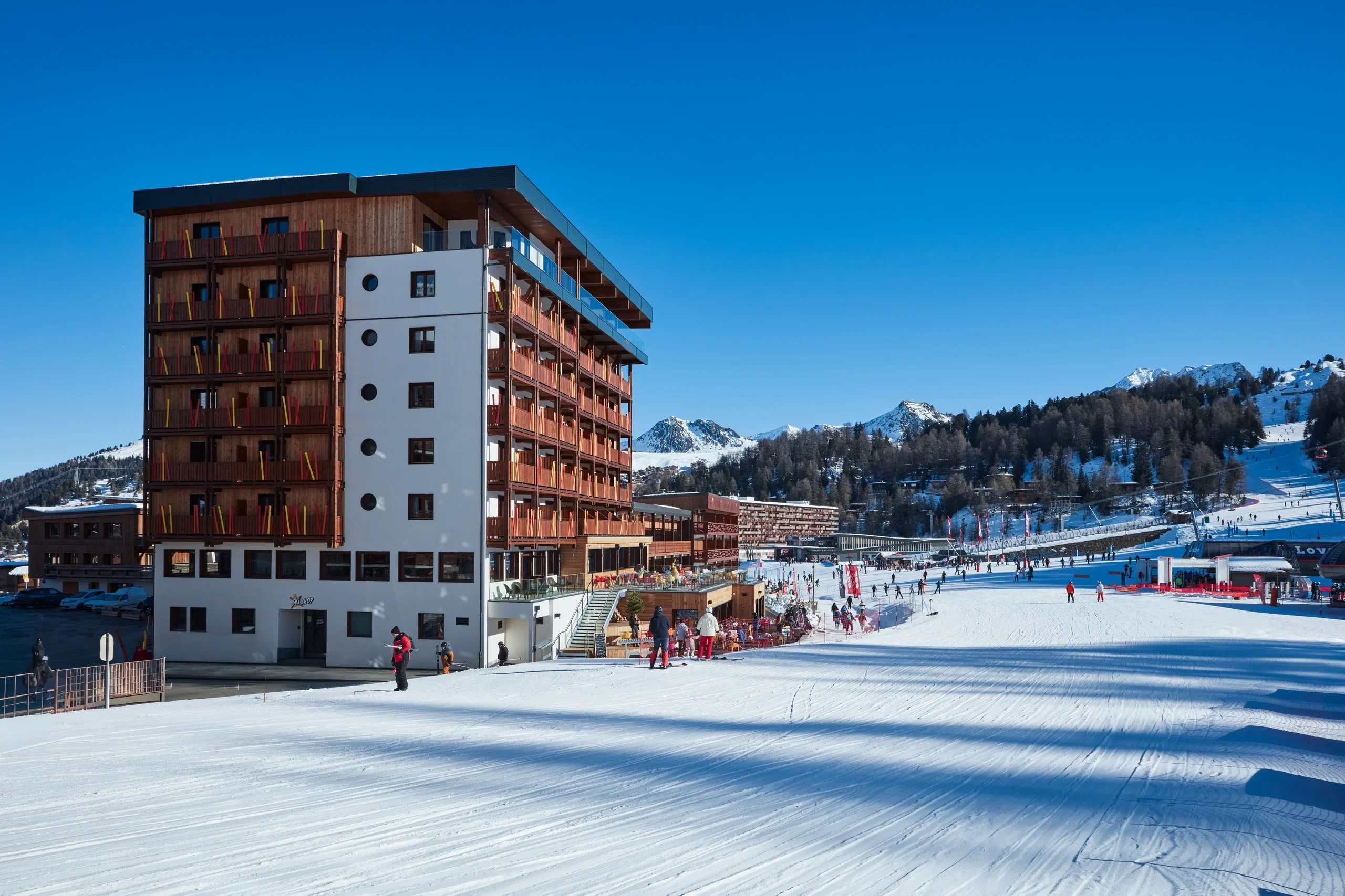 Station de ski avec bâtiment et skieurs.