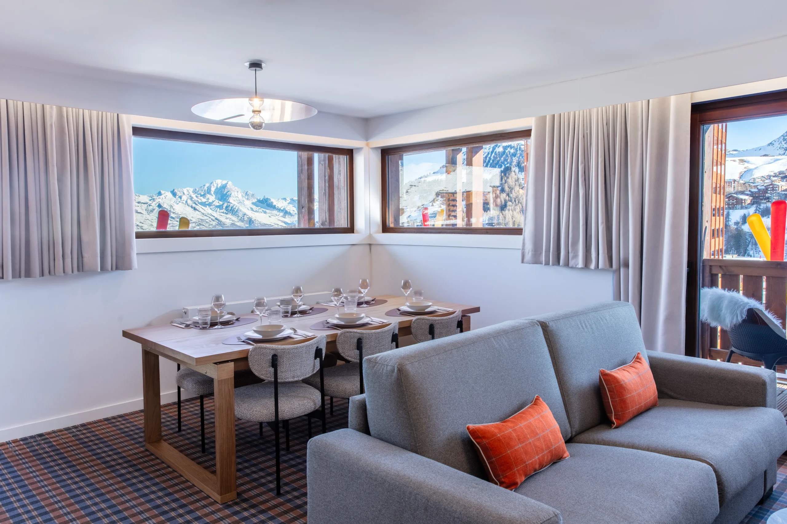 Salon avec vue sur les montagnes enneigées.