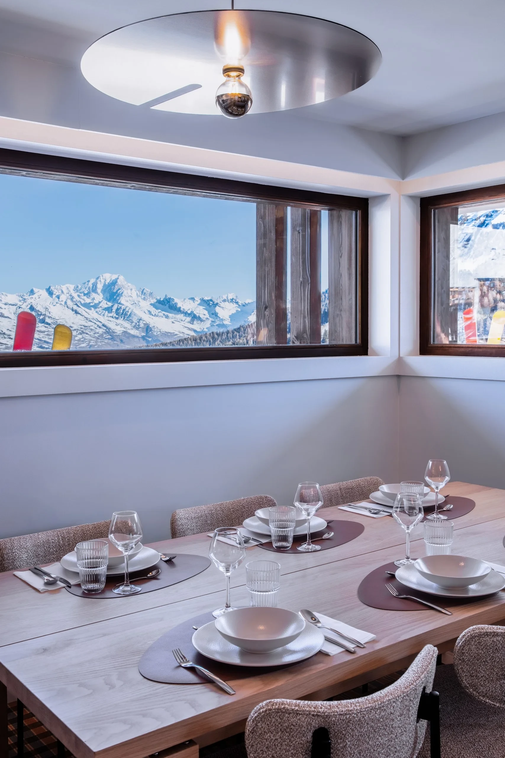 Salle à manger avec vue sur montagne enneigée.