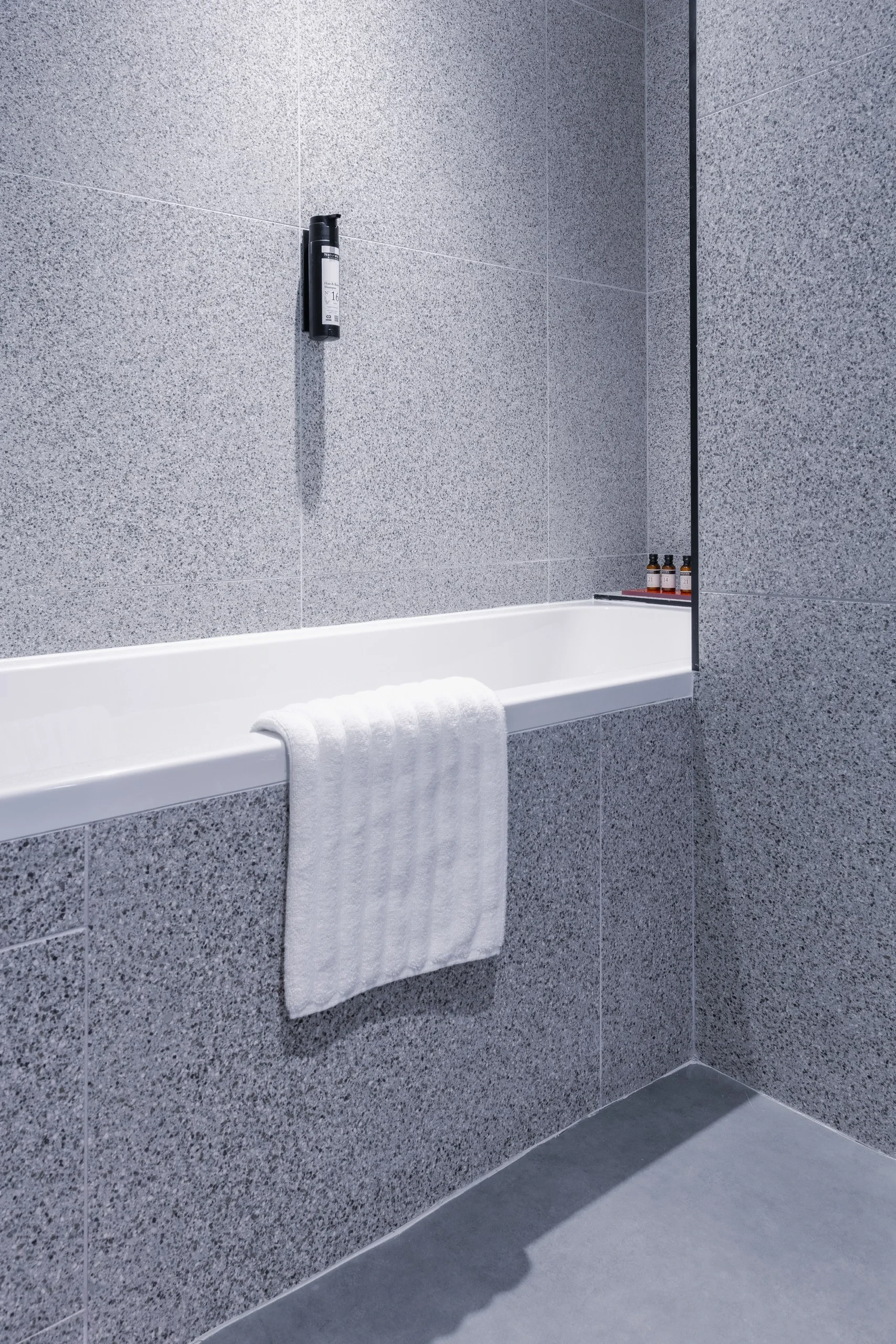 Salle de bain moderne avec carrelage gris.