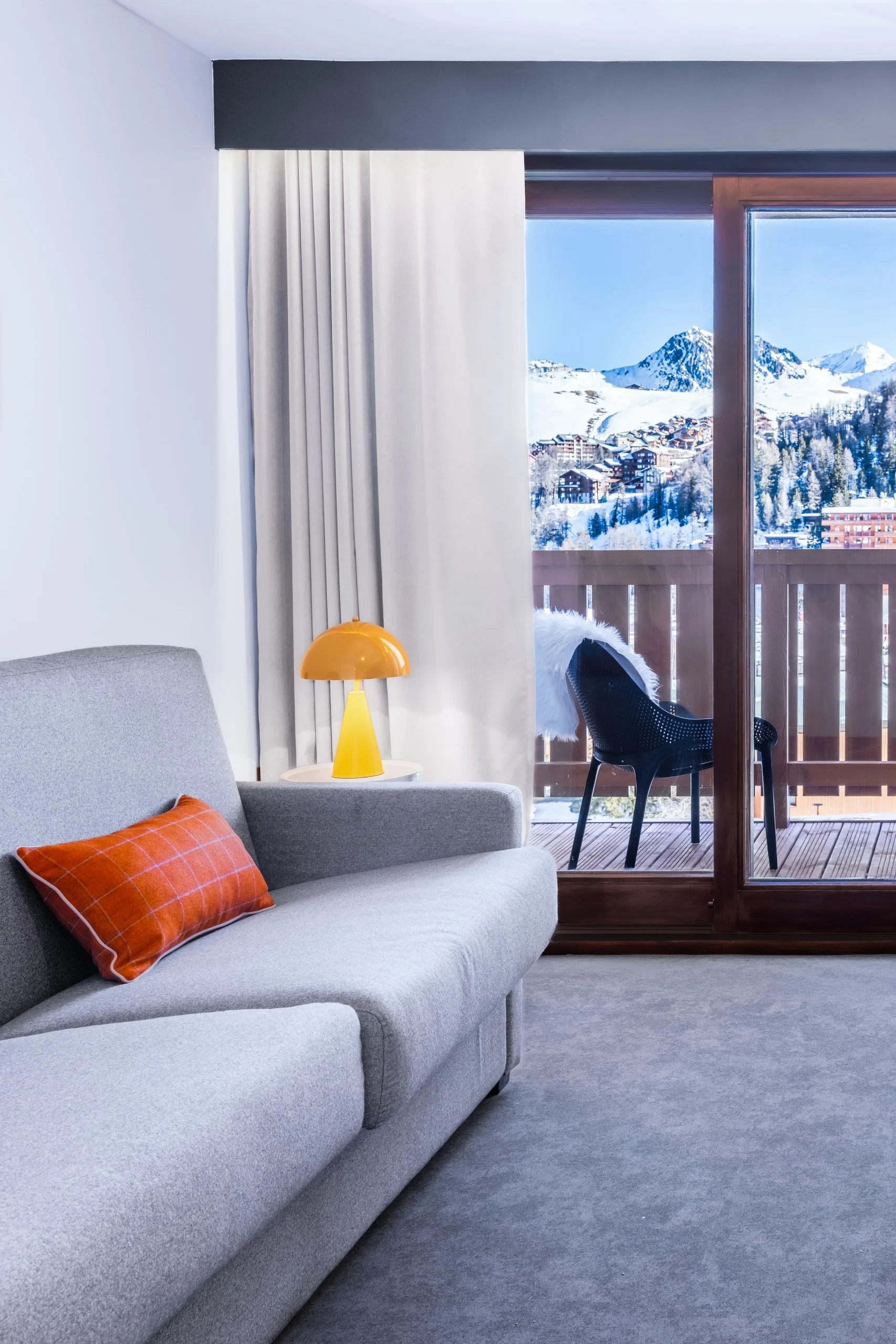 Salon avec vue sur montagnes enneigées.