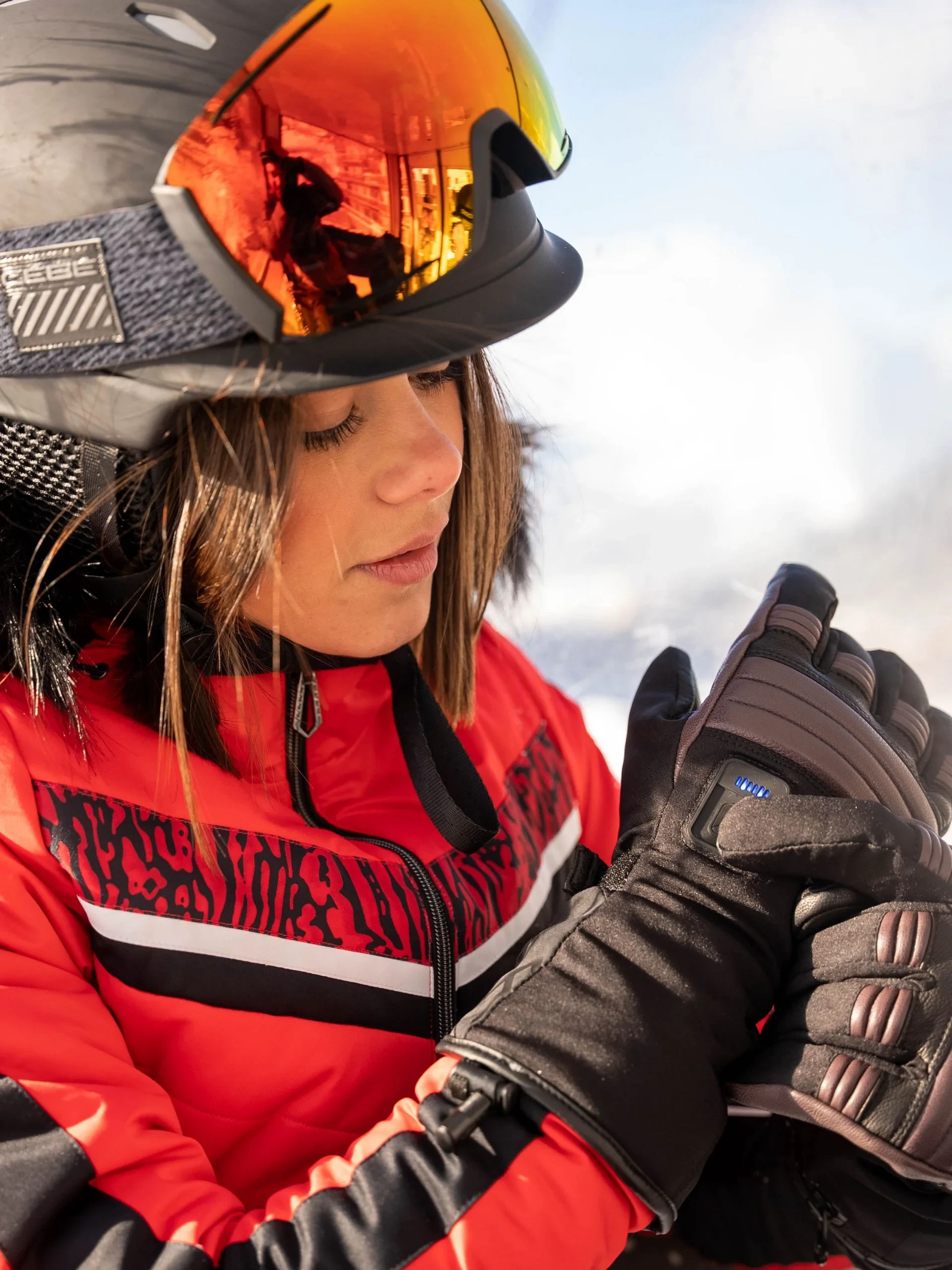 Femme en tenue de ski rouge avec casque.