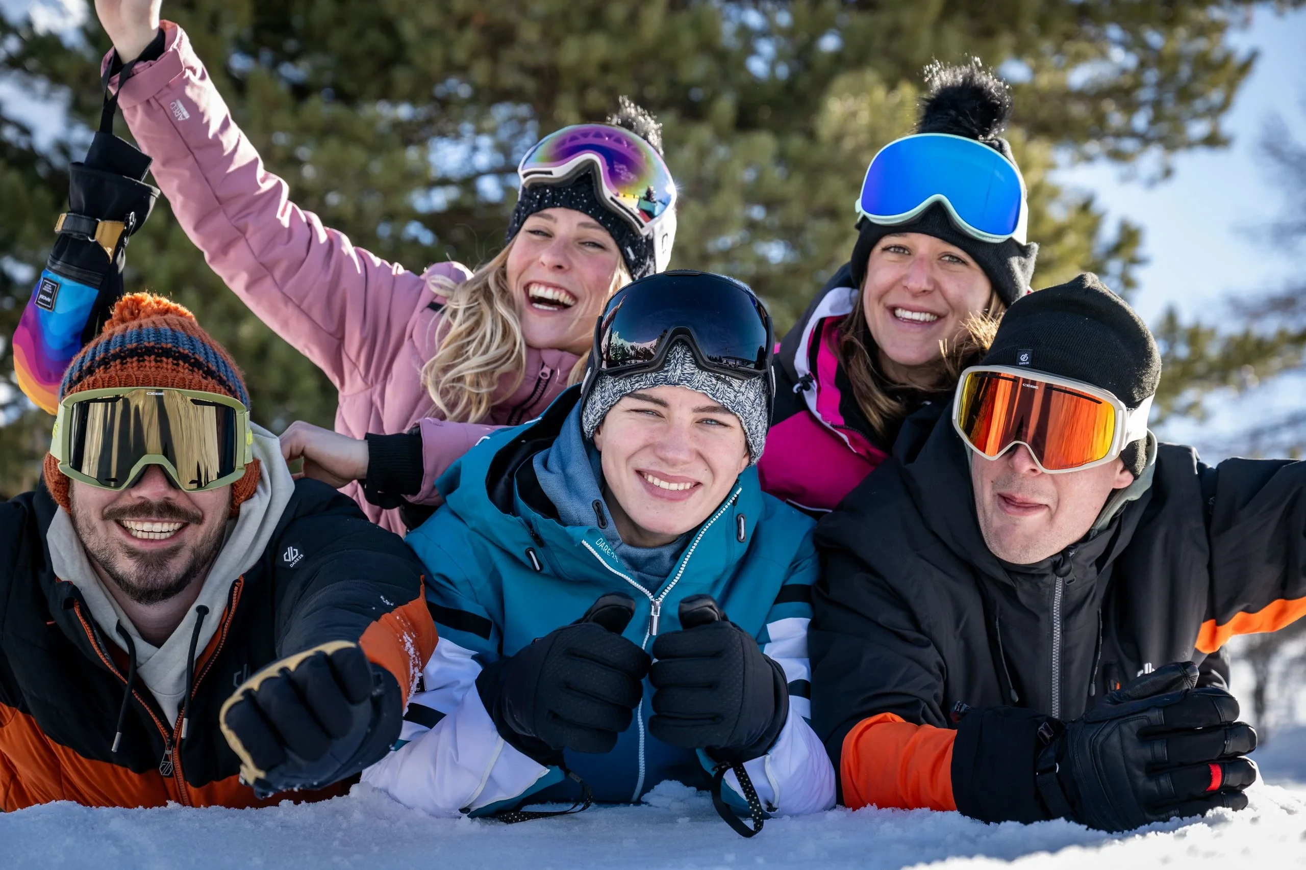 Groupe joyeux en vêtements de ski dans la neige.